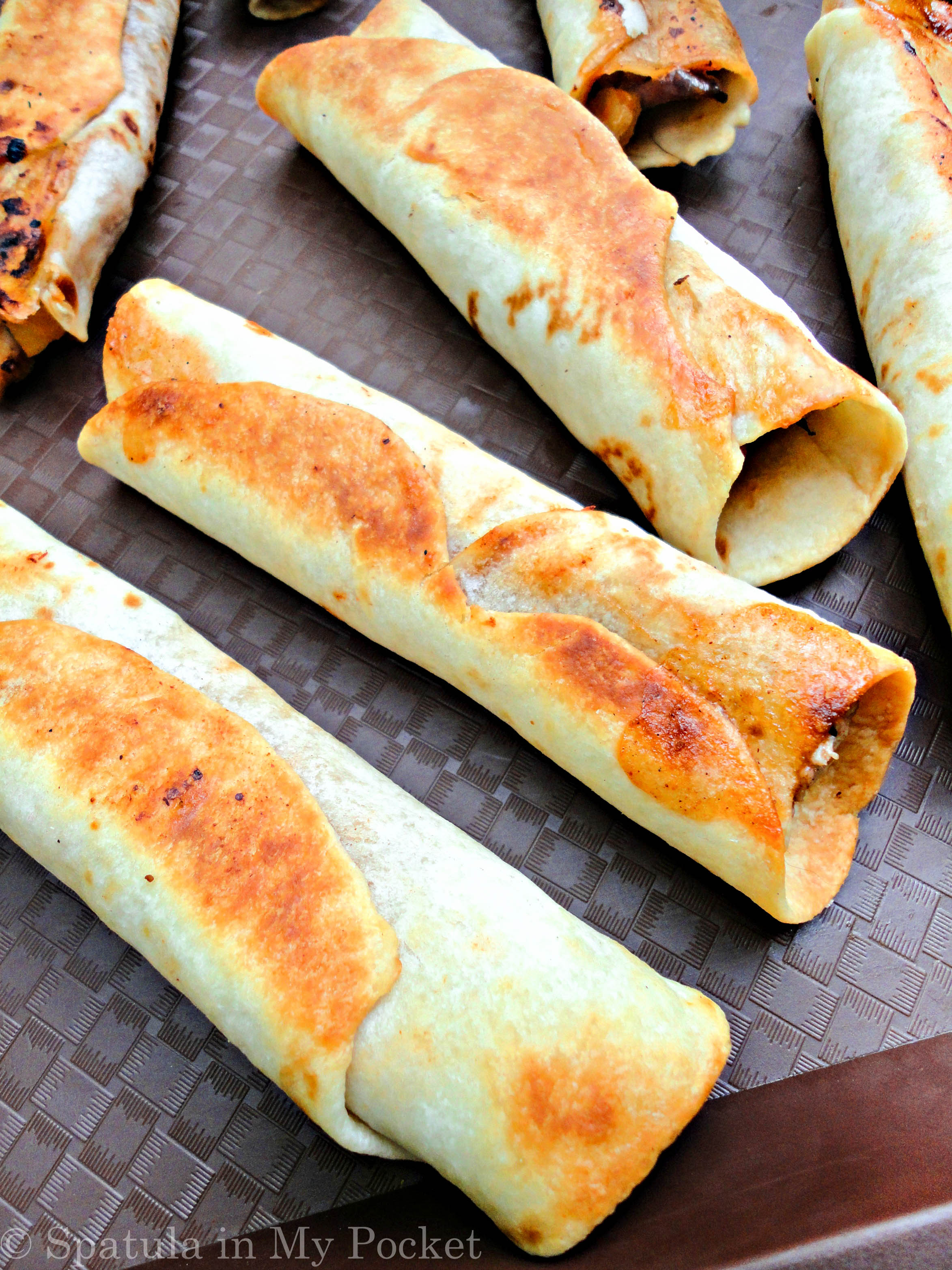 Hawaiian BBQ Taquitos. Filled with pineapples and mangoes, paired with a spicy tangy BBQ chicken, caramelized onions, and loads of fresh cheddar cheese.