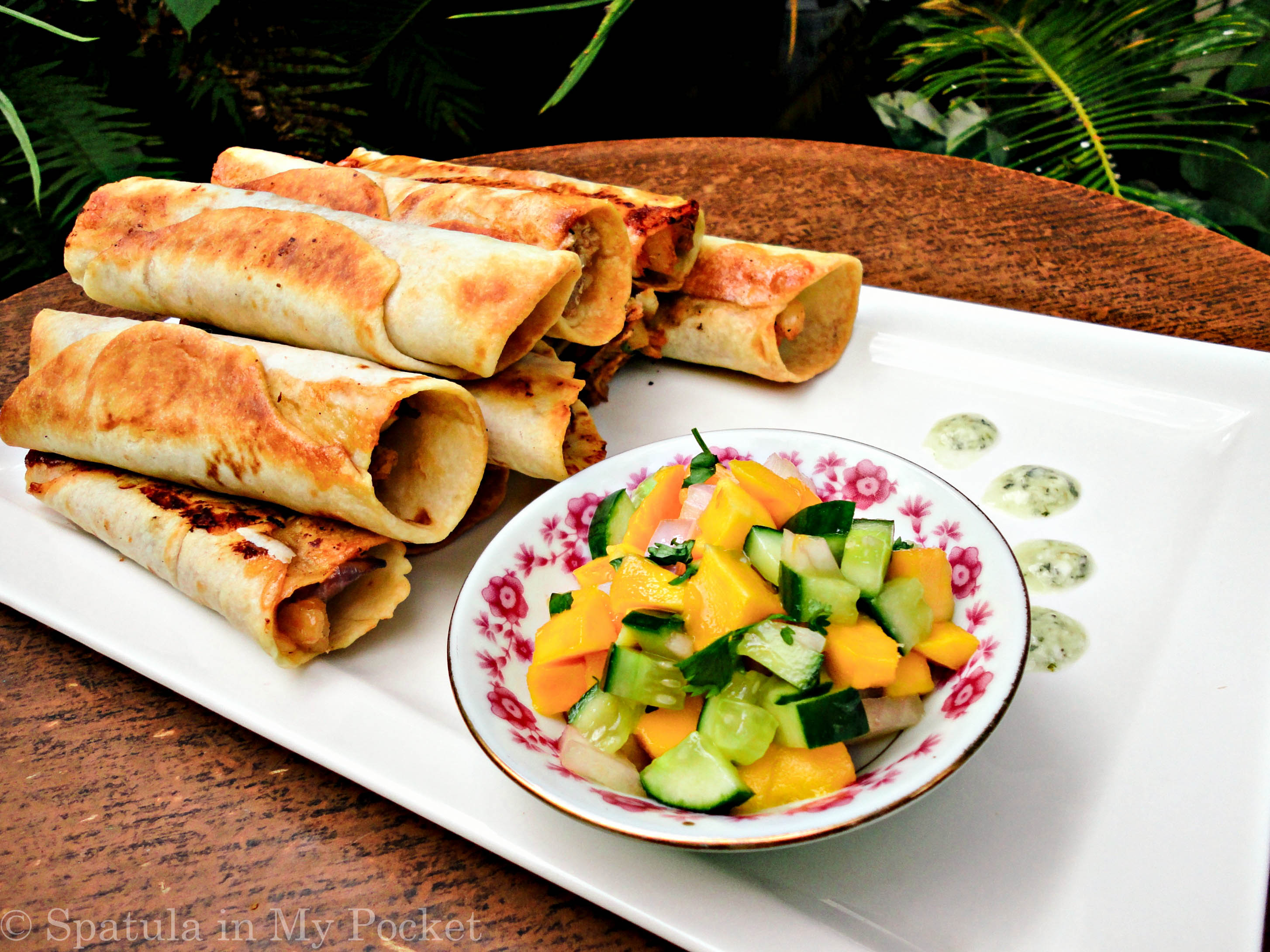 Hawaiian BBQ Taquitos. Filled with pineapples and mangoes, paired with a spicy tangy BBQ chicken, caramelized onions, and loads of fresh cheddar cheese.