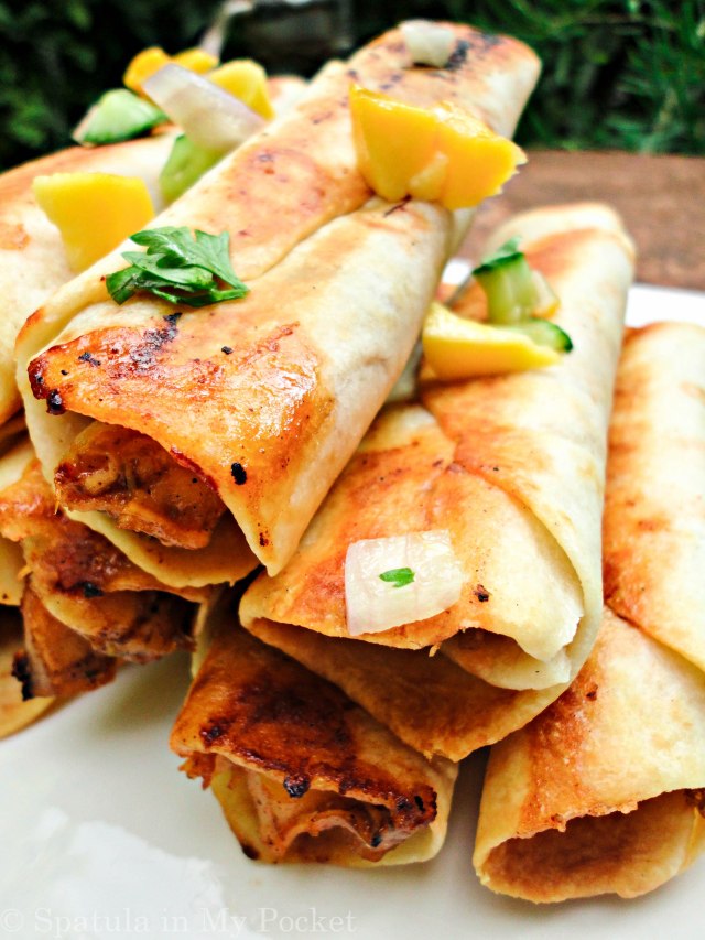 Hawaiian BBQ Taquitos. Filled with pineapples and mangoes, paired with a spicy tangy BBQ chicken, caramelized onions, and loads of fresh cheddar cheese.
